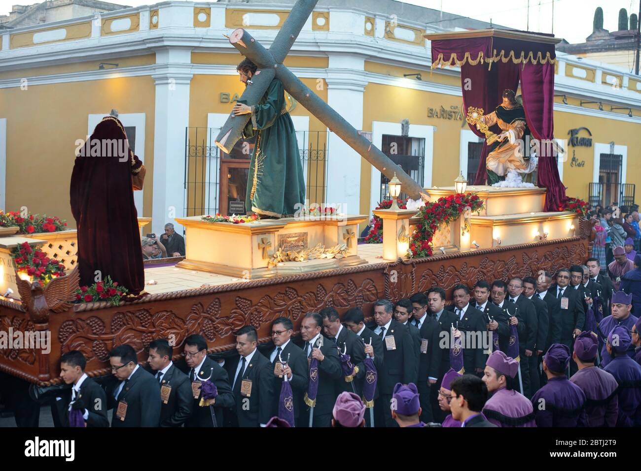 Processione marchers che trasportano il galleggiamento pesante di Cristo che porta la croce. Celebrazione passando attraverso Central Park, Quetzaltenango, Guatemala. Mar 2019 Foto Stock