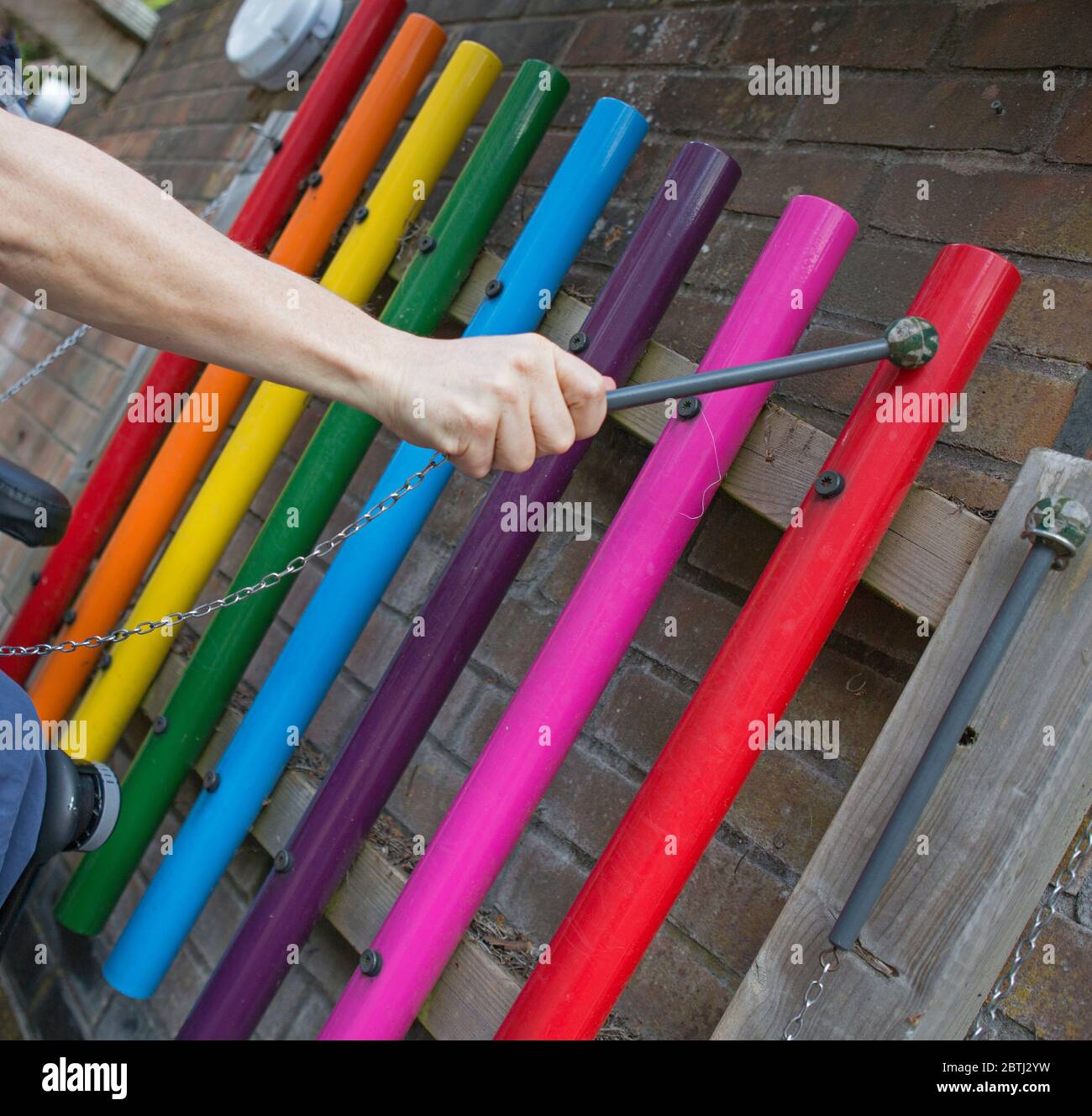 Un colorato giardino strumento musicale campane tubolari. I colori e i suoni luminosi fanno un suono perfetto di chimes musicali in Essex, Inghilterra. Foto Stock