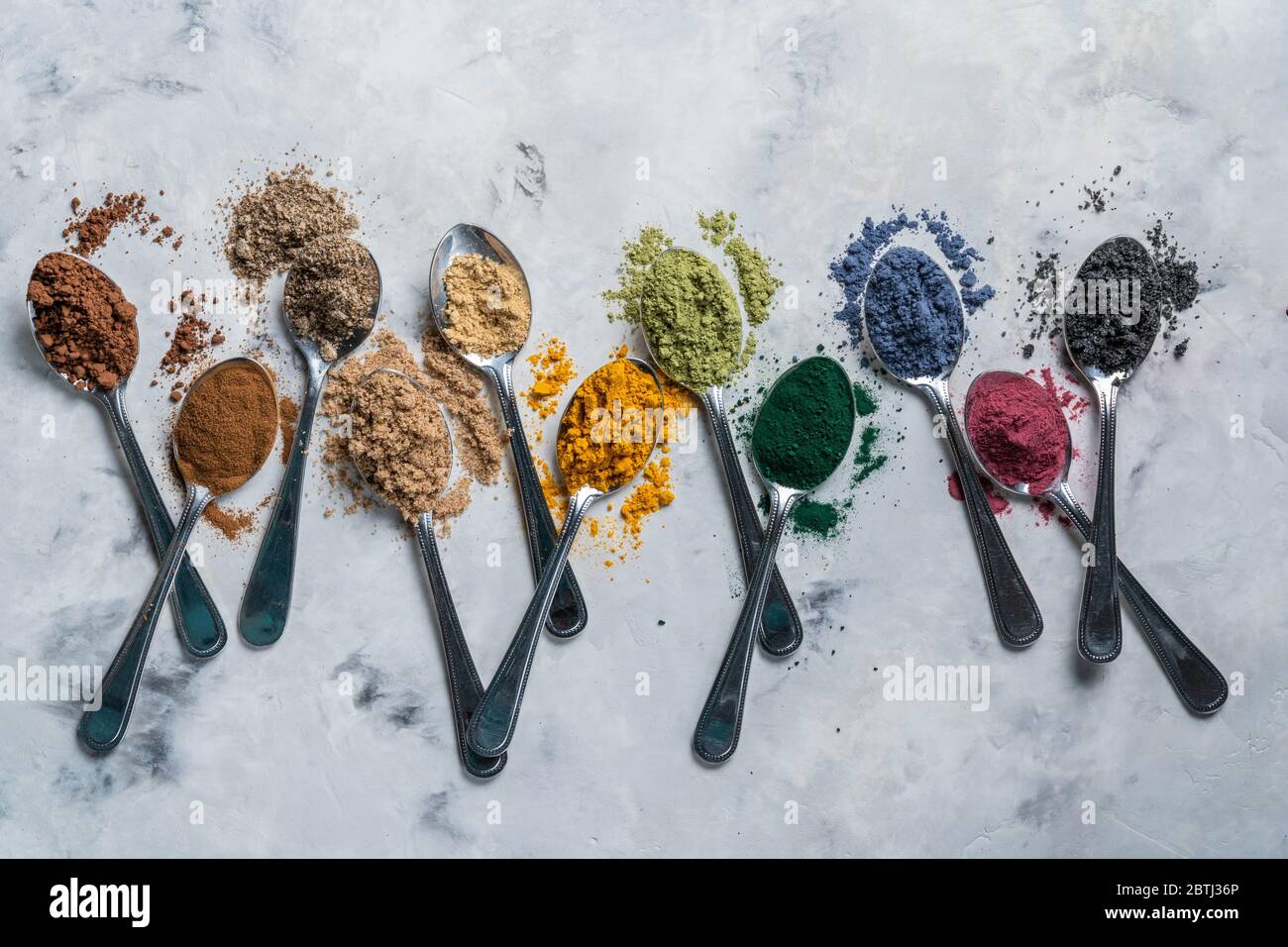 Polveri super in cucchiai - matcha, curcuma, zenzero, cacao, spirulina, chia, cannella, sesamo nero Foto Stock