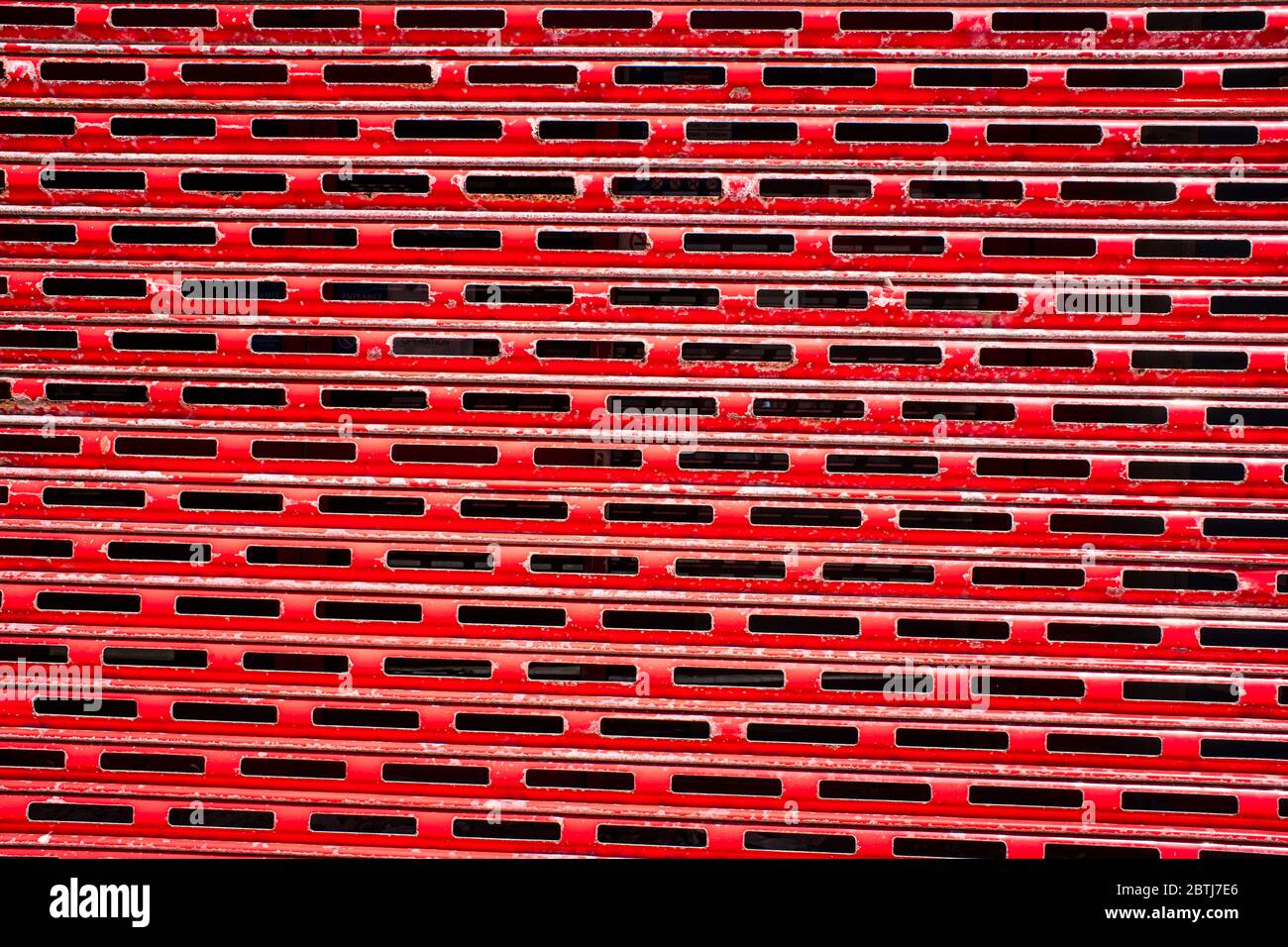 Arrugginito, rosso peeling edificio persiane sfondo. Foto Stock