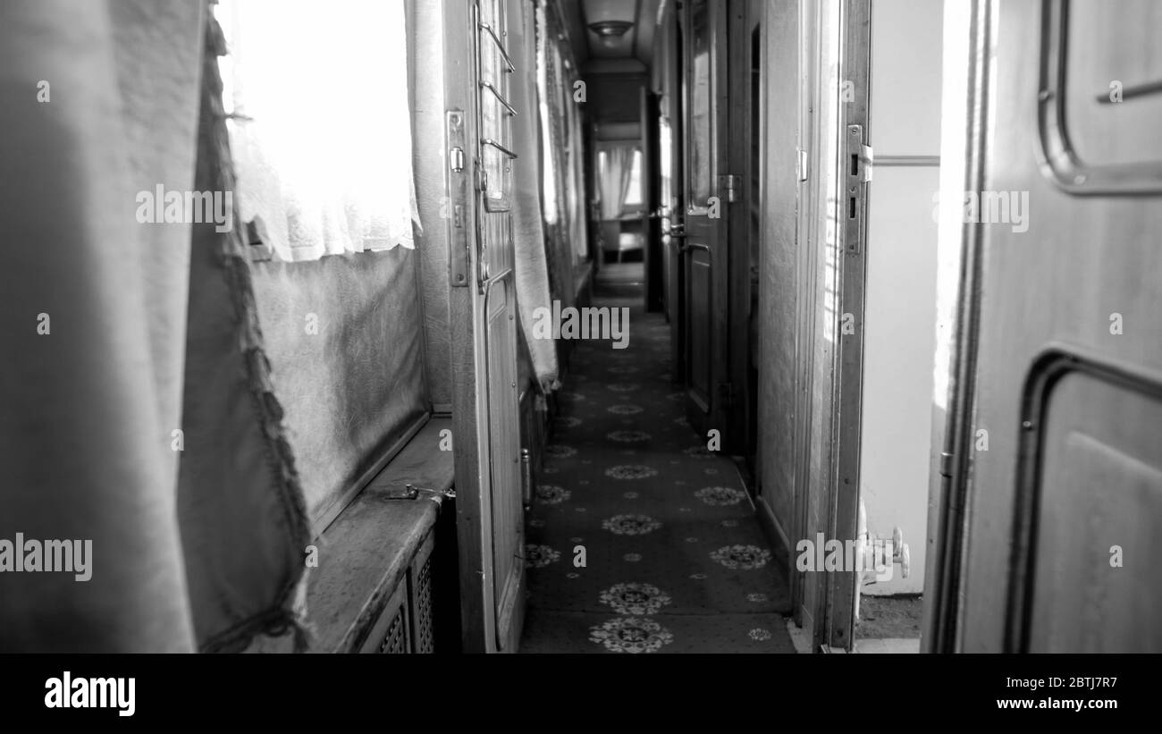 Immagine in bianco e nero di lungo corridoio stretto in una carrozza ferroviaria d'epoca Foto Stock
