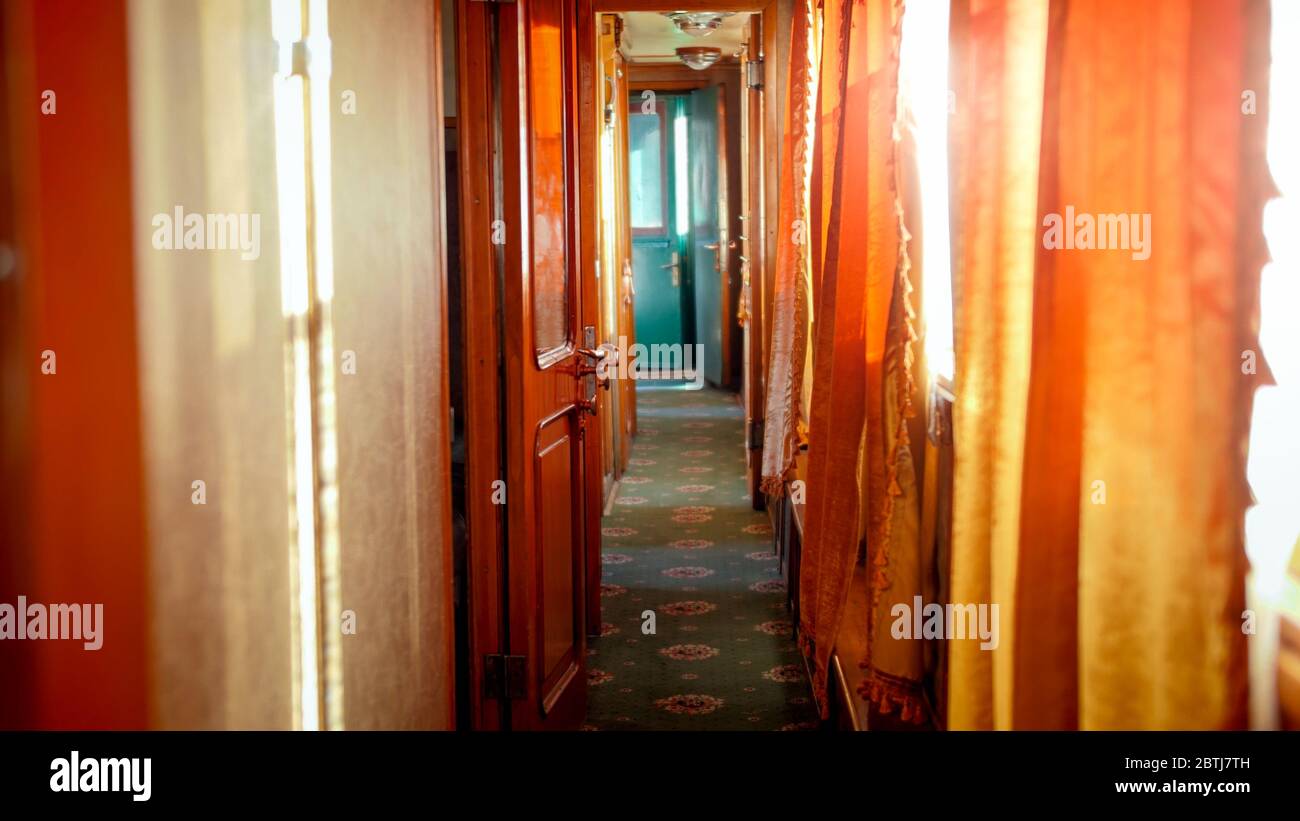 Bellissimo interno di un treno a vapore retrò con porte in legno e tappeti sul pavimento Foto Stock