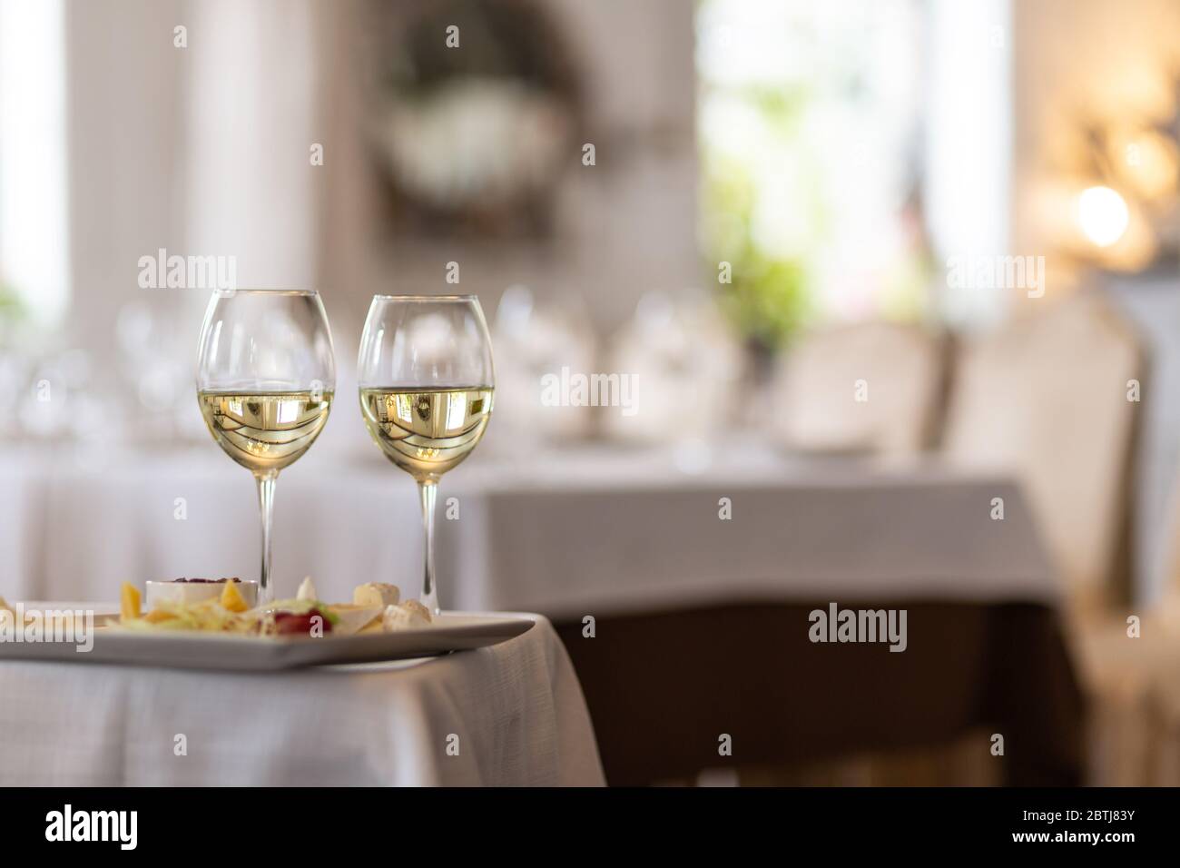 Foto di bottiglia con champagne versato in bicchieri di vino su sfondo grigio Foto Stock