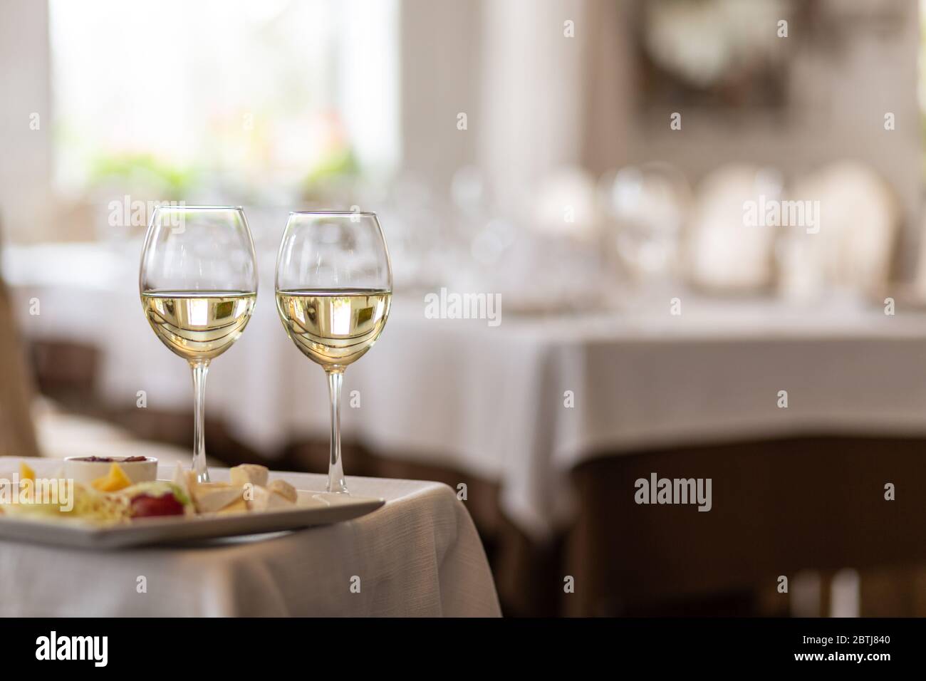 Foto di bottiglia con champagne versato in bicchieri di vino su sfondo grigio Foto Stock