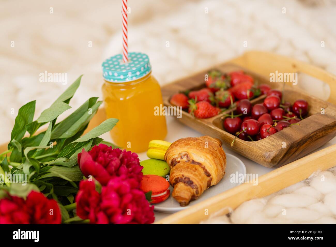 prima colazione a letto con caffè, croissant, fragole e succo di frutta Foto Stock