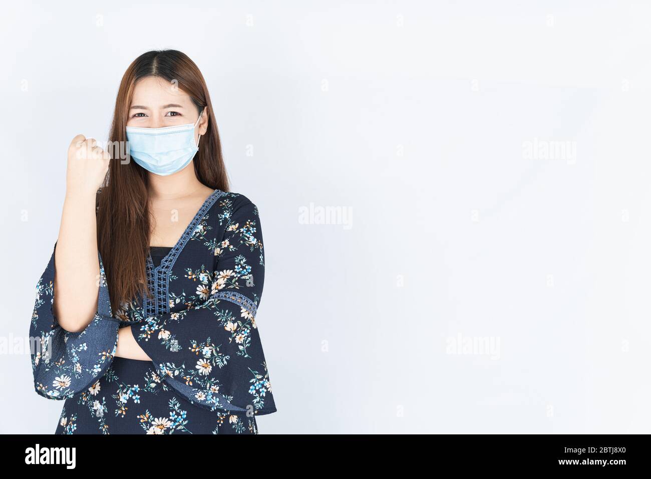 Asian bella donna hipster felice che indossa una maschera medica di protezione per proteggere il coronavirus, filtro polvere PM 2.5 e freddo e sollevare la mano Foto Stock