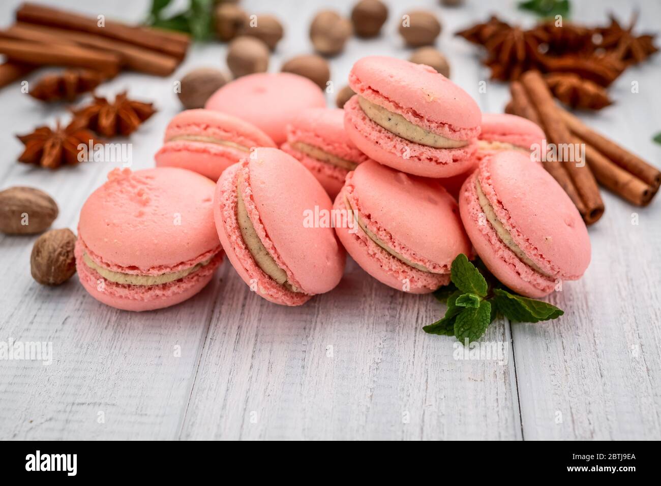 Macaron parigini, macaron rosa su un tavolo di legno bianco Foto Stock