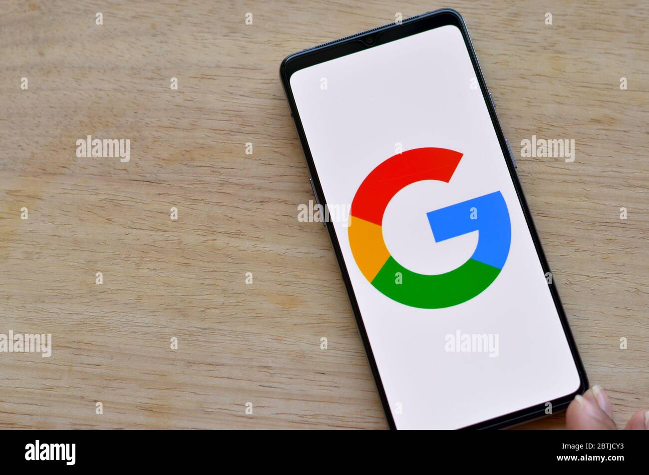 California, Stati Uniti, 2020. Piatto con logo Google su uno schermo mobile su sfondo di legno. Foto Stock