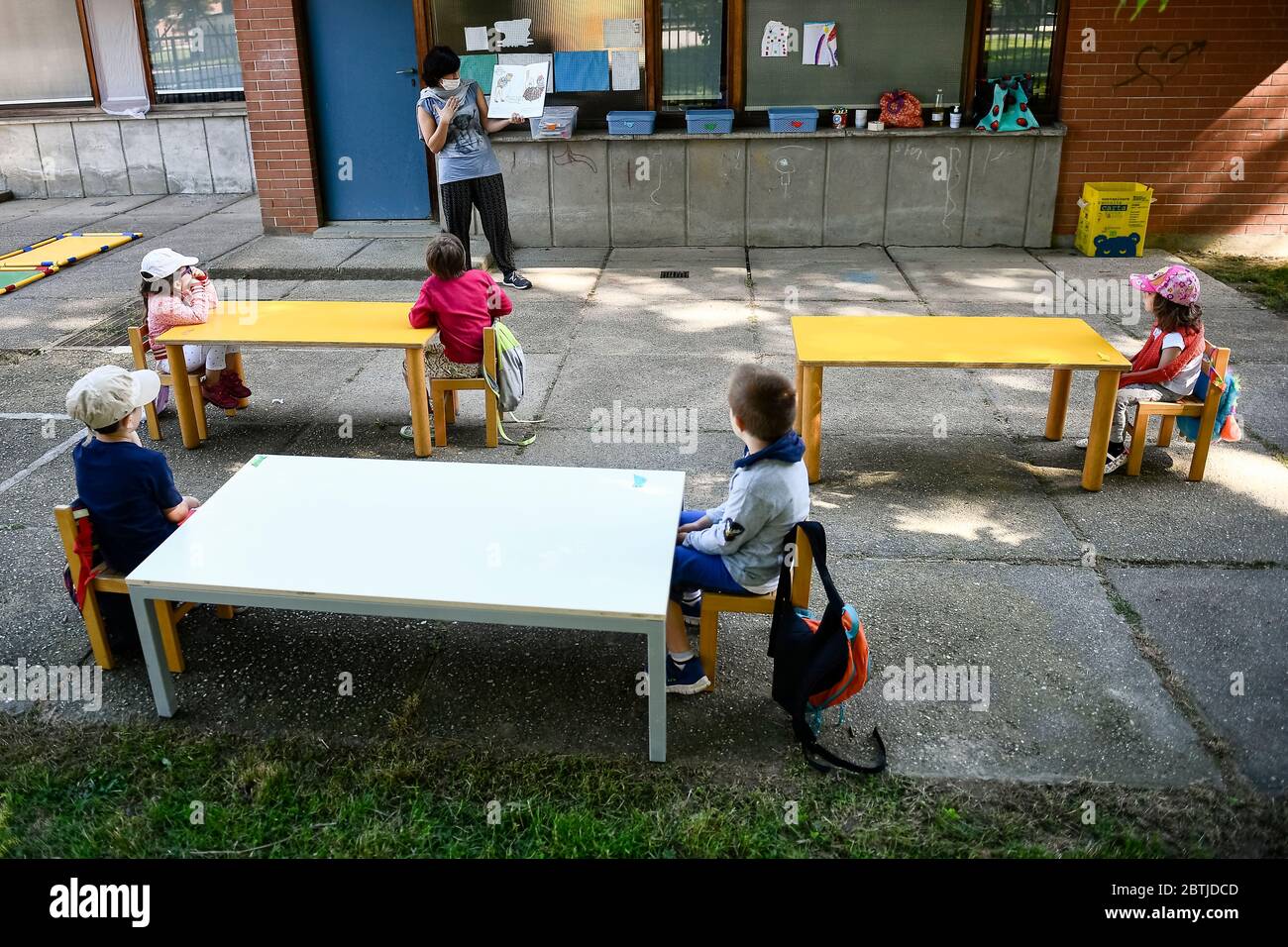 IVREA, ITALIA - 26 maggio 2020: Un insegnante legge un libro per bambini in un giardino scolastico. Il comune di Ivrea apre i giardini di due scuole di asilo come parte di un test pilota per vedere come le scuole possono riaprire dopo il blocco del coronavirus COVID-19. (Foto di Nicolò campo/Sipa USA) Foto Stock