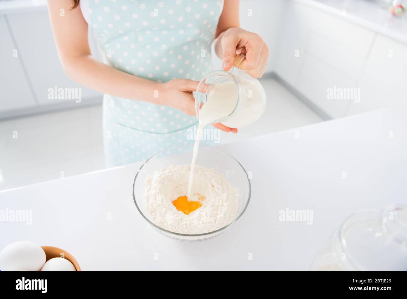 Foto ritagliata di casalinga fine settimana della mattina presto preparare biscotti per i bambini di famiglia marito fare pasta versare aggiungendo latte moderna cucina al chiuso Foto Stock