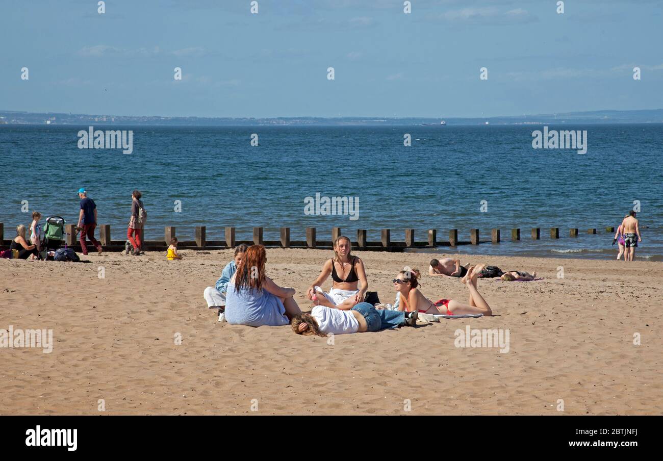 Portobello, Edimburgo, Scozia, Regno Unito. 26 maggio 2020. Atmosfera più rilassata al mare nel tardo pomeriggio, quando la Scozia si avvicina alla fine della fase 1 di Coronavirus Lockdown. Temperatura di 19 gradi e soleggiata. Le persone si divertono a sedersi sulla spiaggia sabbiosa con meno apprensione di essere spostati. Foto Stock