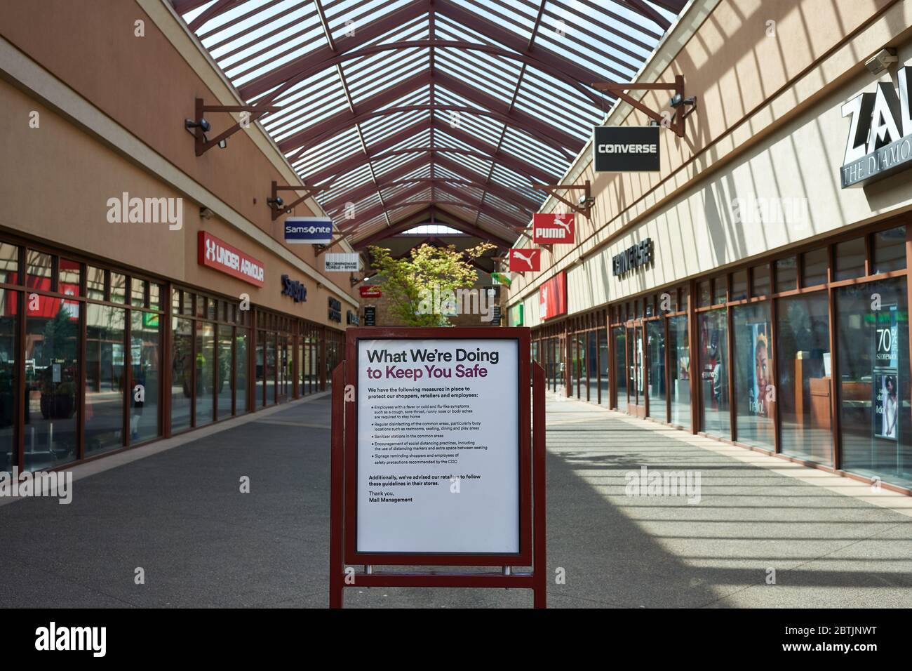 Un cartello che informa gli acquirenti delle misure di sicurezza in atto per impedire la diffusione del COVID-19 nei Woodburn Premium Outlets riaperti il Memorial Day. Foto Stock