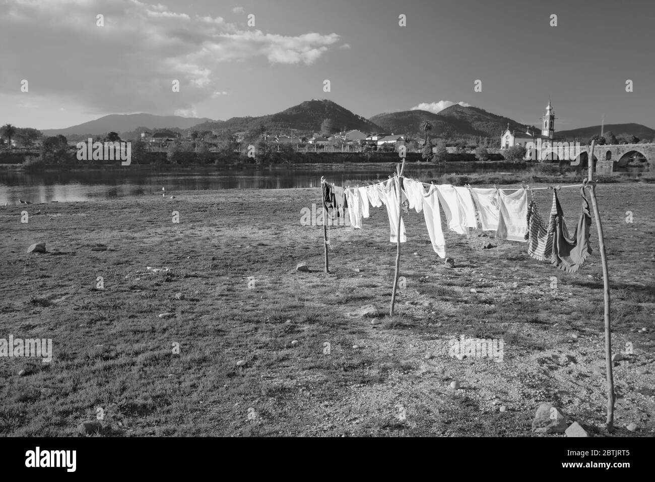 Paesaggio rurale bianco e nero con vestiti che asciugano in primo piano, accanto al fiume Lima, Ponte de Lima, Portogallo settentrionale Foto Stock