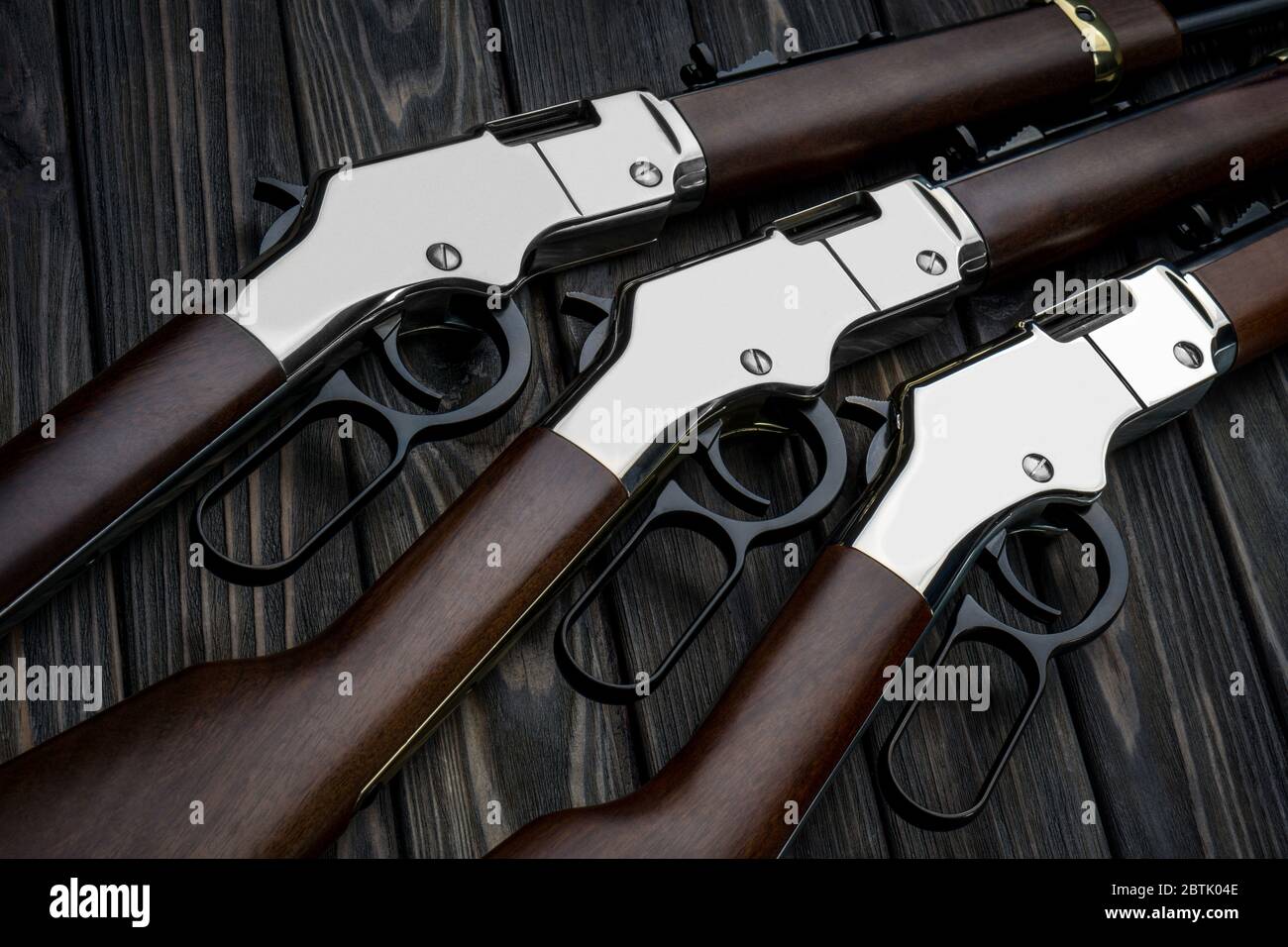 Cowboy si riga su uno sfondo di legno. Fucili d'epoca del selvaggio West. Armi di cowboy, sceriffi e banditi. Foto Stock