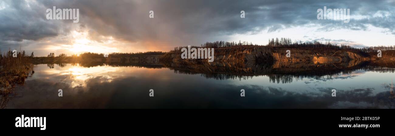 Immagine speculare nel lago di ripide rive al tramonto. Vsevolozhsk. Leningrad region.Panorama . Foto Stock