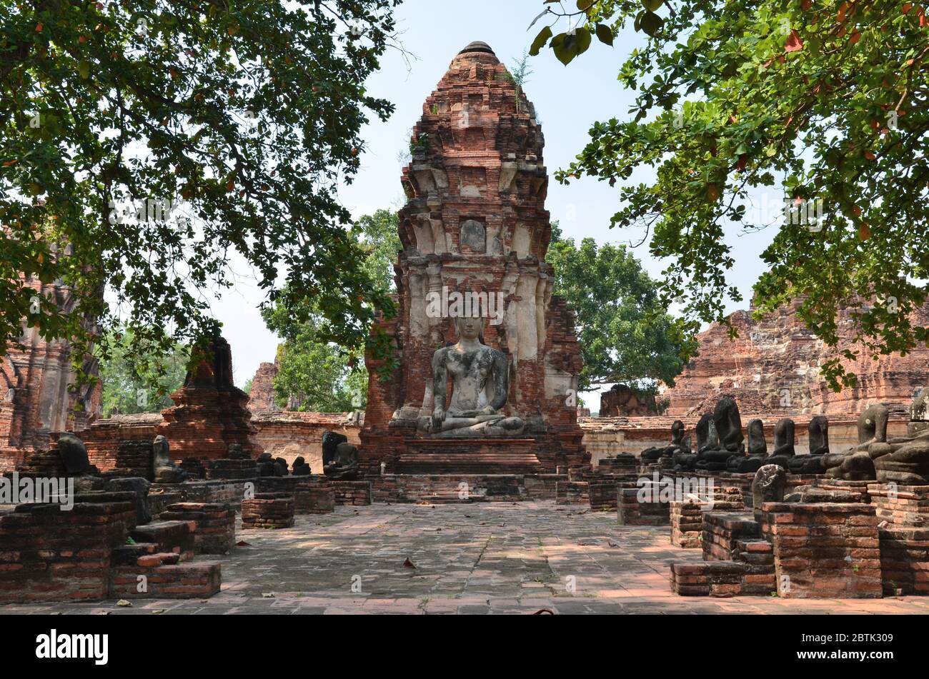 Bella chedi con una statua di Buddha seduto di fronte, Wat Phra Mahathat in Ayutthaya Foto Stock