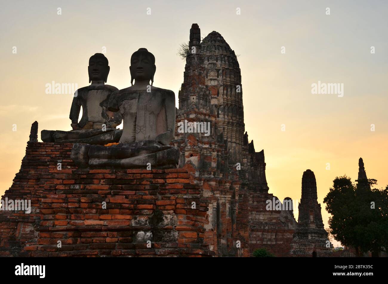 Statue di Buddha di fronte al prang impressionante a Wat Chaiwatthanaram in Ayutthaya Foto Stock