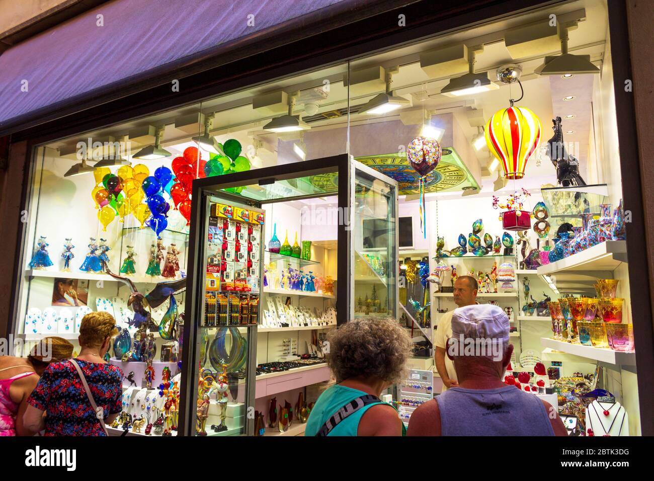 Turisti che guardano una vetrina con vetro di Murano in una strada commerciale vicino a Piazza San Marco nel centro storico di Venezia, giugno 2016 Foto Stock