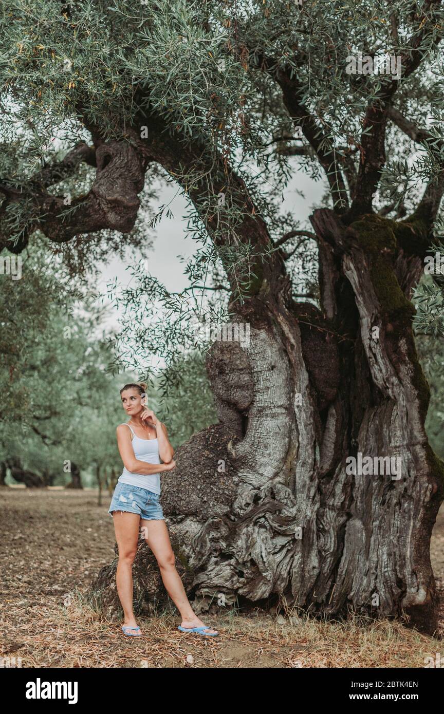 Bella donna sotto un albero di ulivo, a piedi all'aperto Foto stock - Alamy