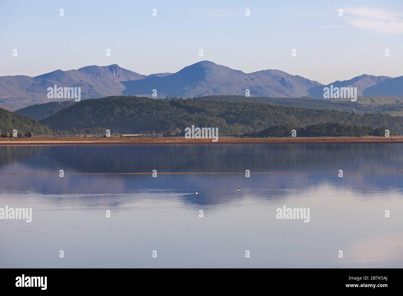 Vista a nord dall'estuario di Levens, Cumbria sud con le colline del distretto del lago riflesse nel fiume Levens Foto Stock