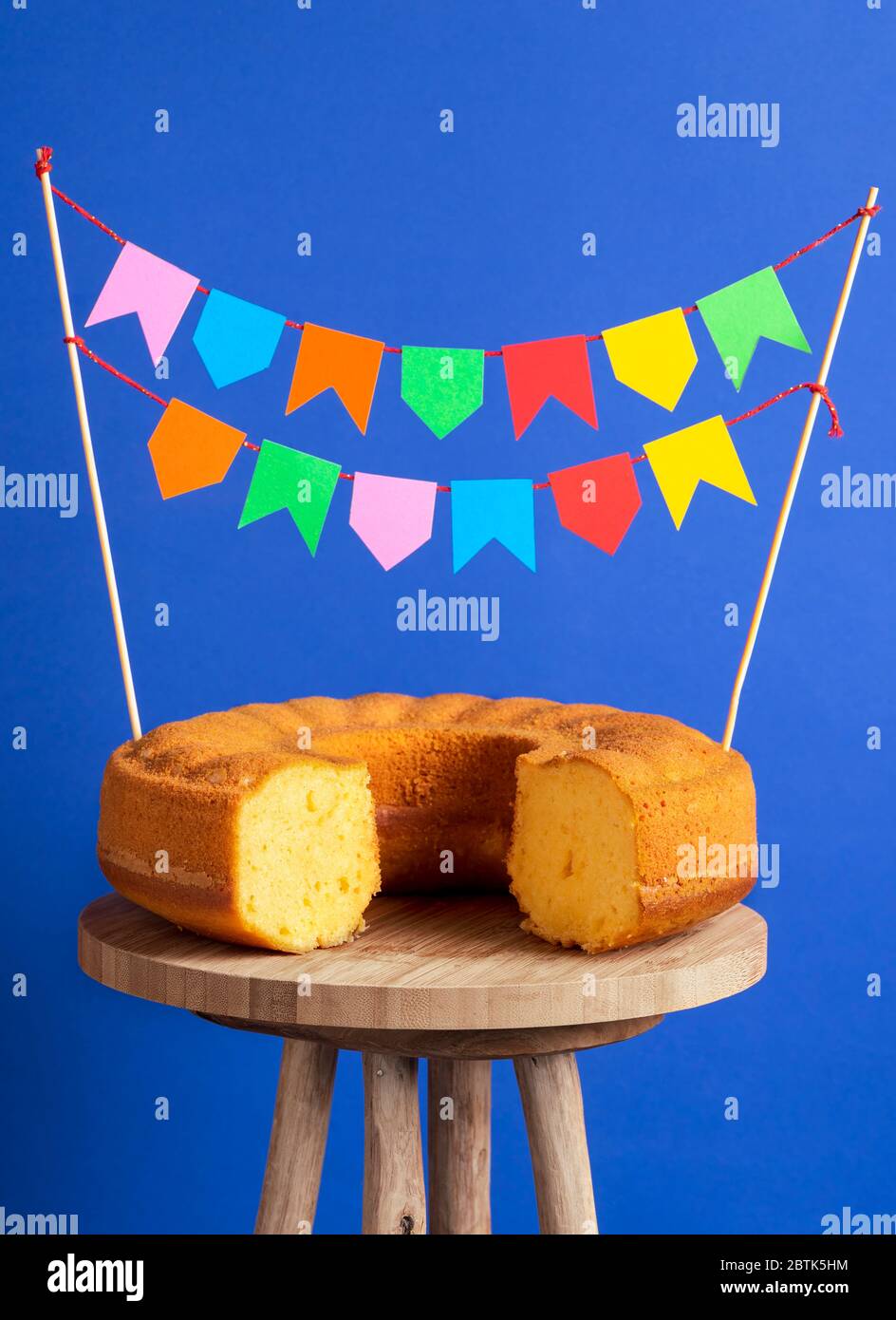 Bandiere di partito bloccato in una torta di farina di mais. Cibo dolce pronto per la famosa festa brasiliana chiamata Festa Junina Foto Stock