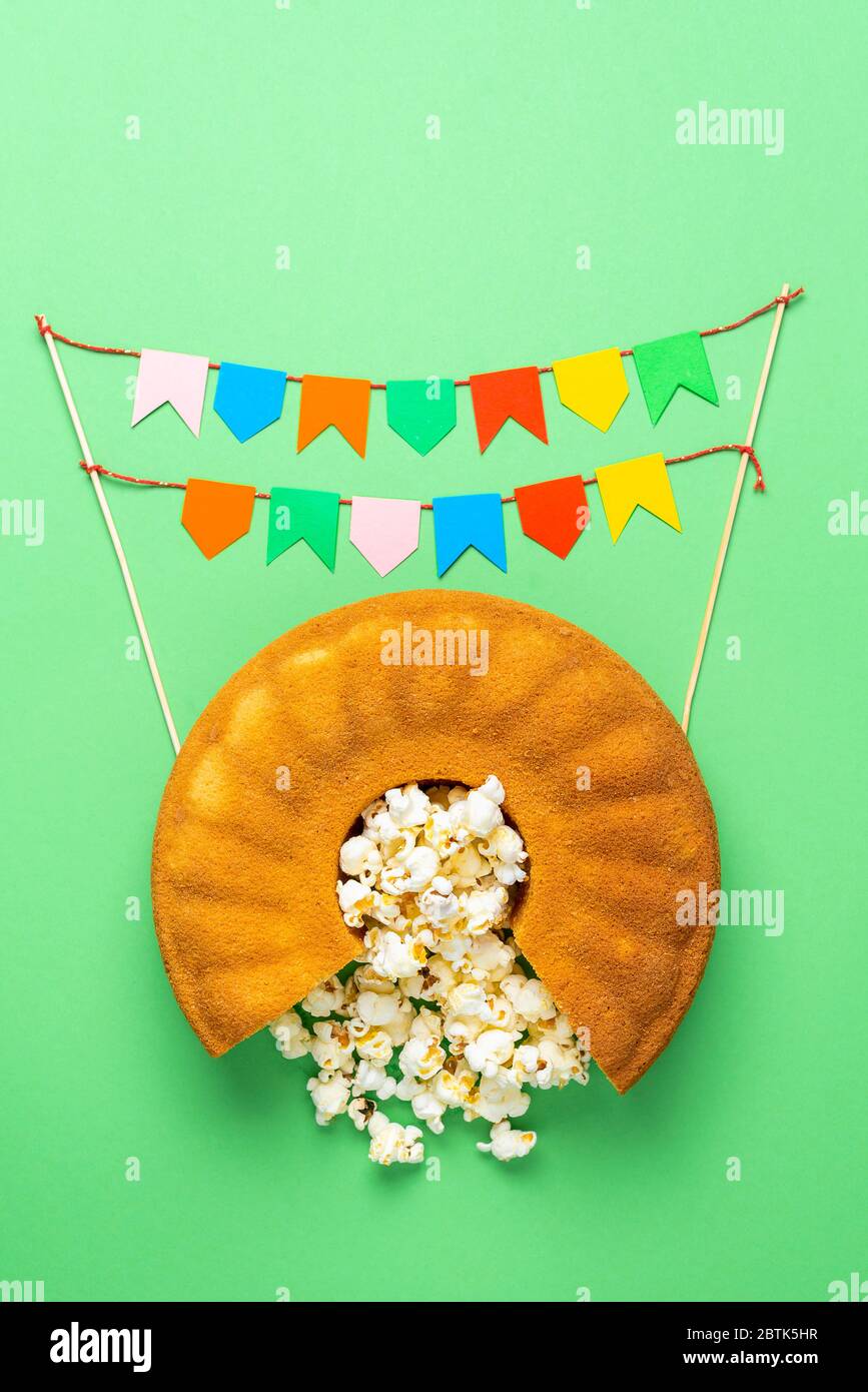 Torta di farina di mais, popcorn e bandiere colorate. Festa Junina cibo. Cucina tradizionale brasiliana per il festival di giugno. Banner festa Junina. Foto Stock