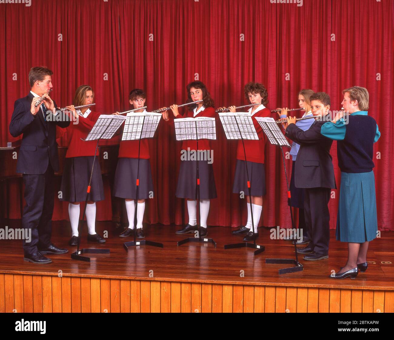 Scolari che giocano flauti sul palco scolastico, Surrey, Inghilterra, Regno Unito Foto Stock