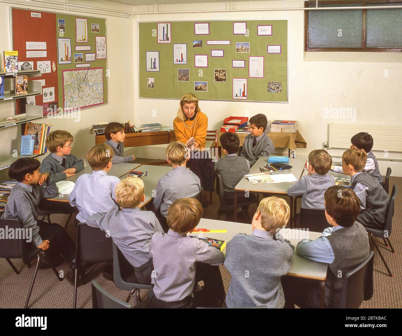 Insegnante femminile che legge in classe, Surrey, Inghilterra, Regno Unito Foto Stock