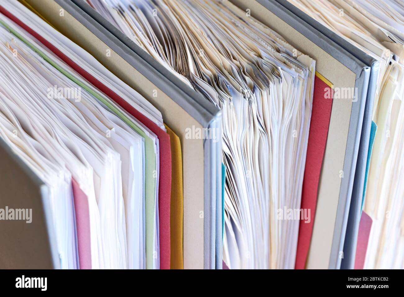 Primo piano di raccoglitori con carta e linguette. Pila di documenti aziendali, fatture o documenti in raccoglitori di documenti. Vita libera da debito, ufficio senza carta. Foto Stock
