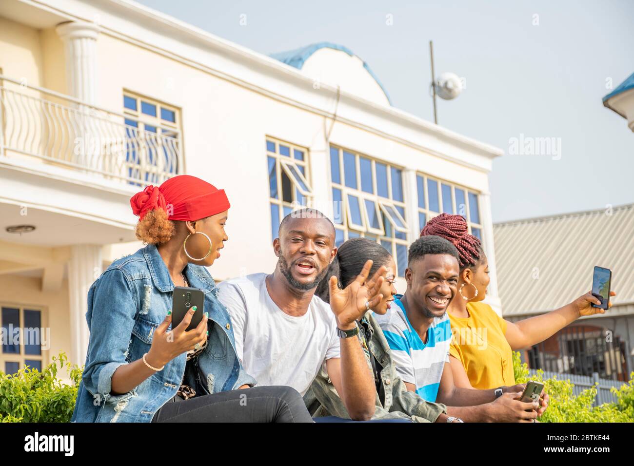 gruppo di giovani amici africani che si agganano insieme all'aperto, divertendosi Foto Stock