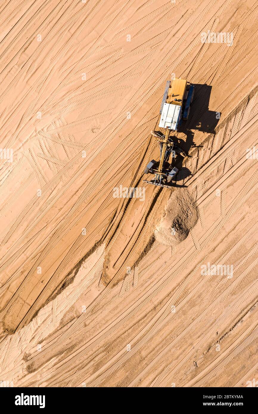 immagine drone aerea del cantiere stradale. livellatrice pesante in movimento e spianatura del terreno Foto Stock