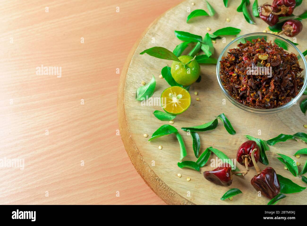 Pasta piccante di peperoni e lime su bacineria di legno Foto Stock