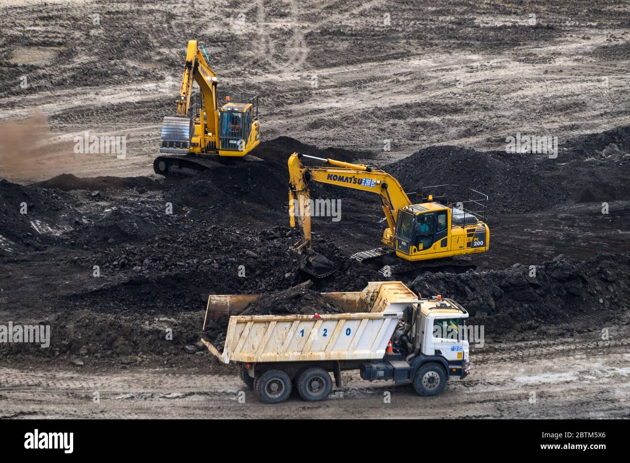 Escavatore che riempie il carbone in un camion di scarico, miniera di carbone a cielo aperto in Borneo indonesia Foto Stock