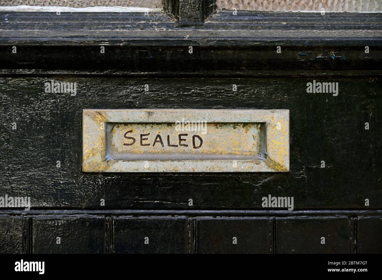 Scatola intestata sigillata su vecchia porta in legno verniciata di nero. Bankfield Road, Kendal, Cumbria, Inghilterra, Regno Unito, Europa. Foto Stock