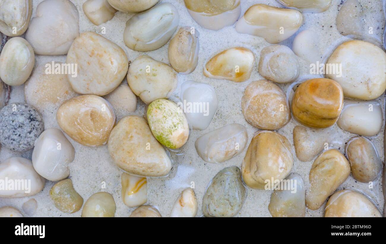 Pietre di mare nell'acqua di mare. Ciottoli sotto l'acqua. La vista dall'alto. Sfondo nautico. Acqua di mare pulita. Mare trasparente. Foto Stock