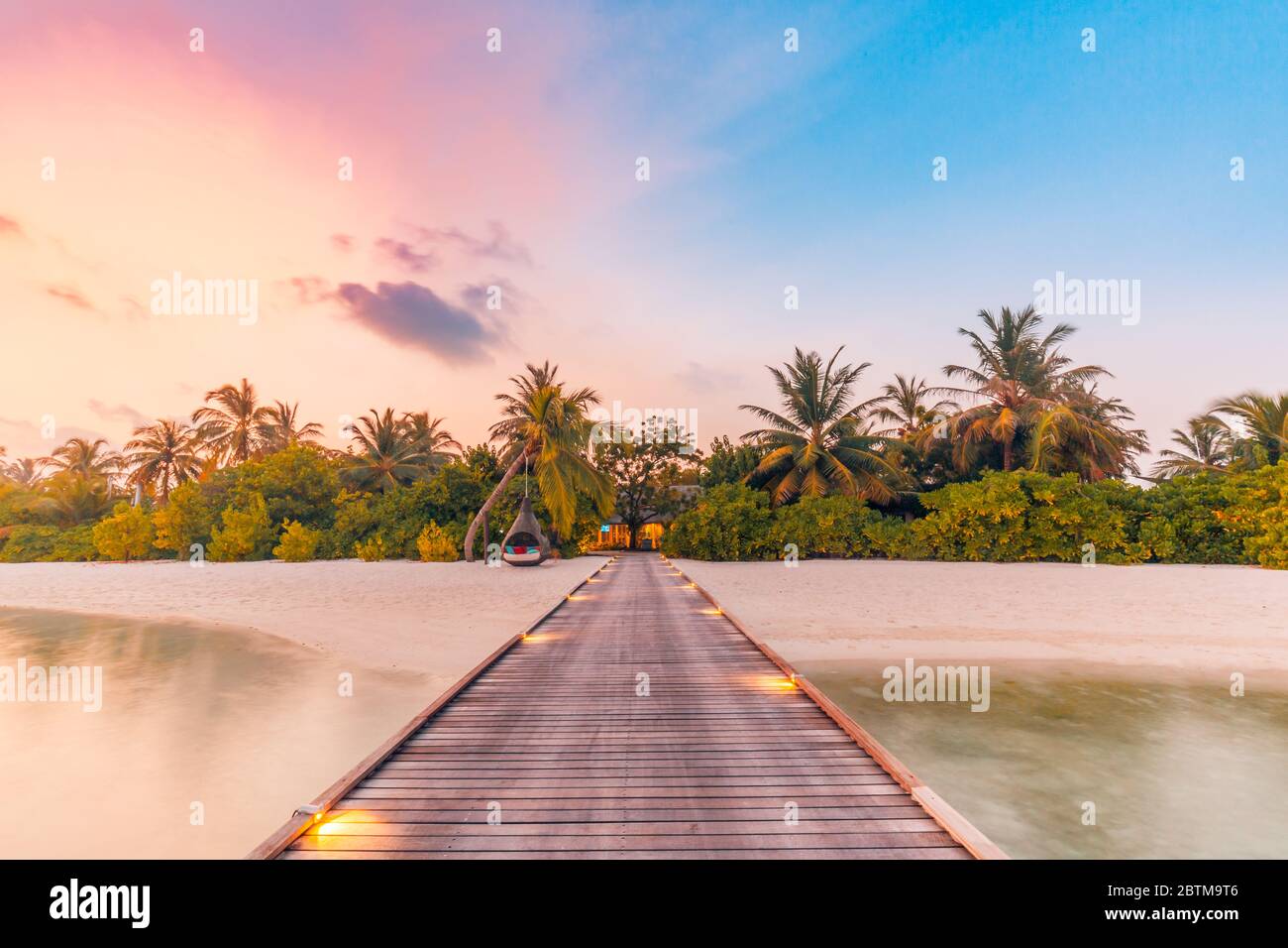 Bella spiaggia tramonto scena. Cielo colorato e nuvole vista con mare calmo e rilassante atmosfera tropicale Foto Stock