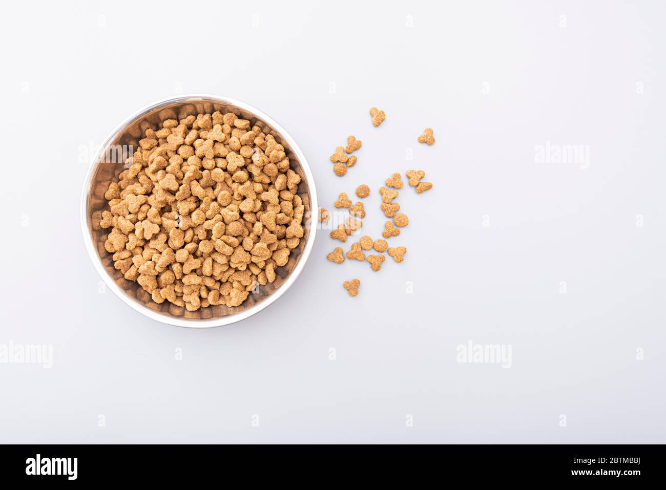 Alimenti per animali domestici in recipiente di ferro su sfondo grigio, alimenti secchi per animali domestici per gatti o cani, vista dall'alto Foto Stock