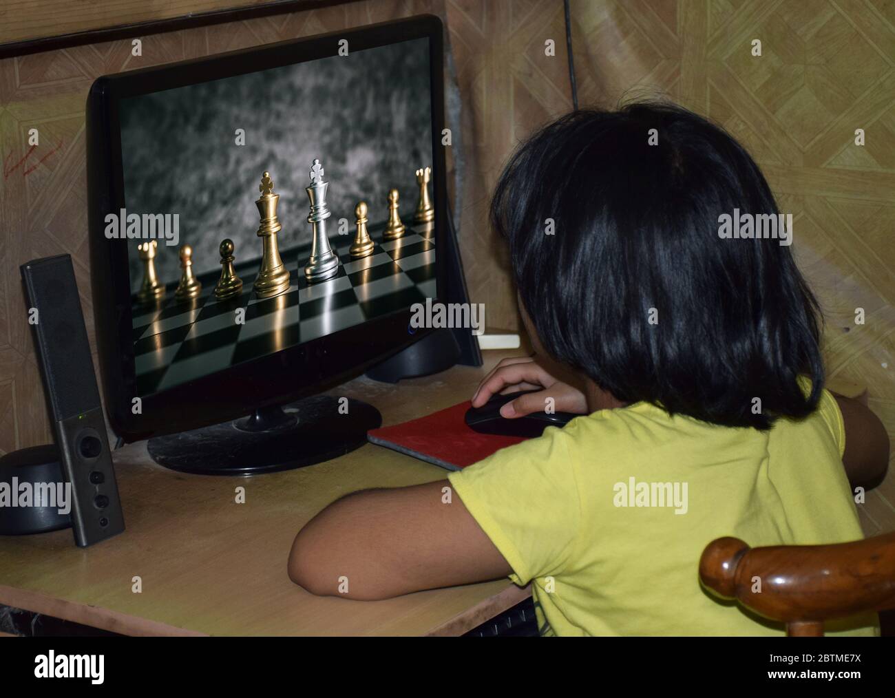 Un bambino indiano che gioca a scacchi con il computer Foto Stock