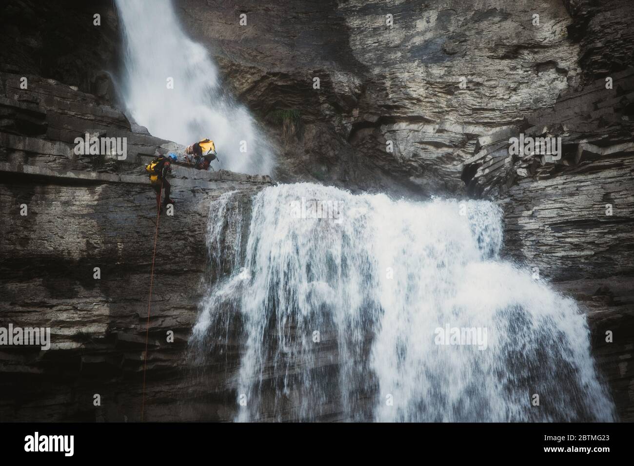 Canyoners che si rapppelling in una cascata, Broto, pirenei spagnoli, Spagna Foto Stock