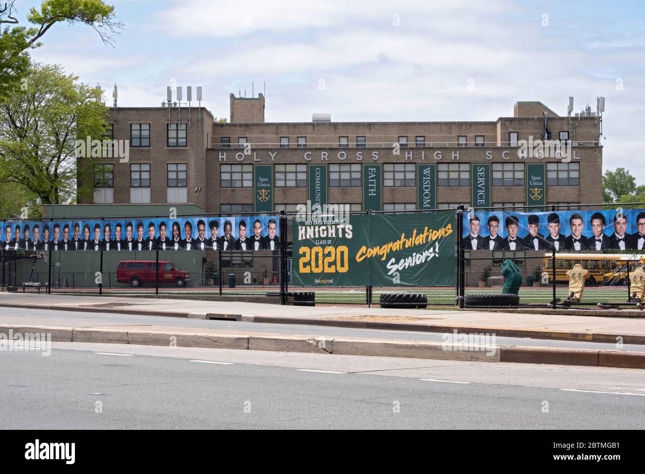 Al posto di una cerimonia di laurea, la Scuola superiore della Santa Croce appese un banner e foto degli anziani laureati. A Flushing, Queens, New York. Foto Stock