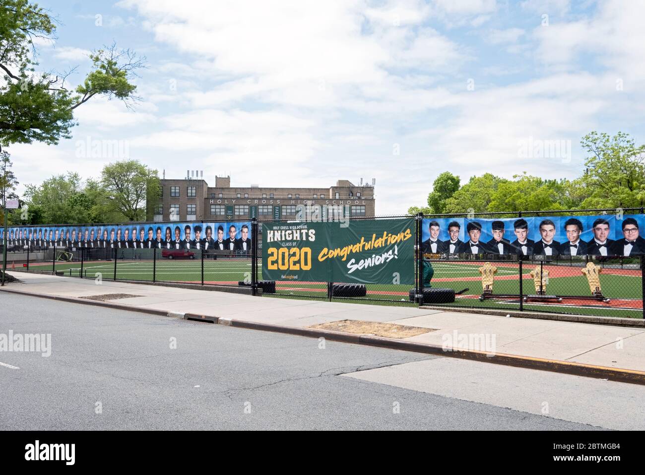 Al posto di una cerimonia di laurea, la Scuola superiore della Santa Croce appese un banner e foto degli anziani laureati. A Flushing, Queens, New York. Foto Stock