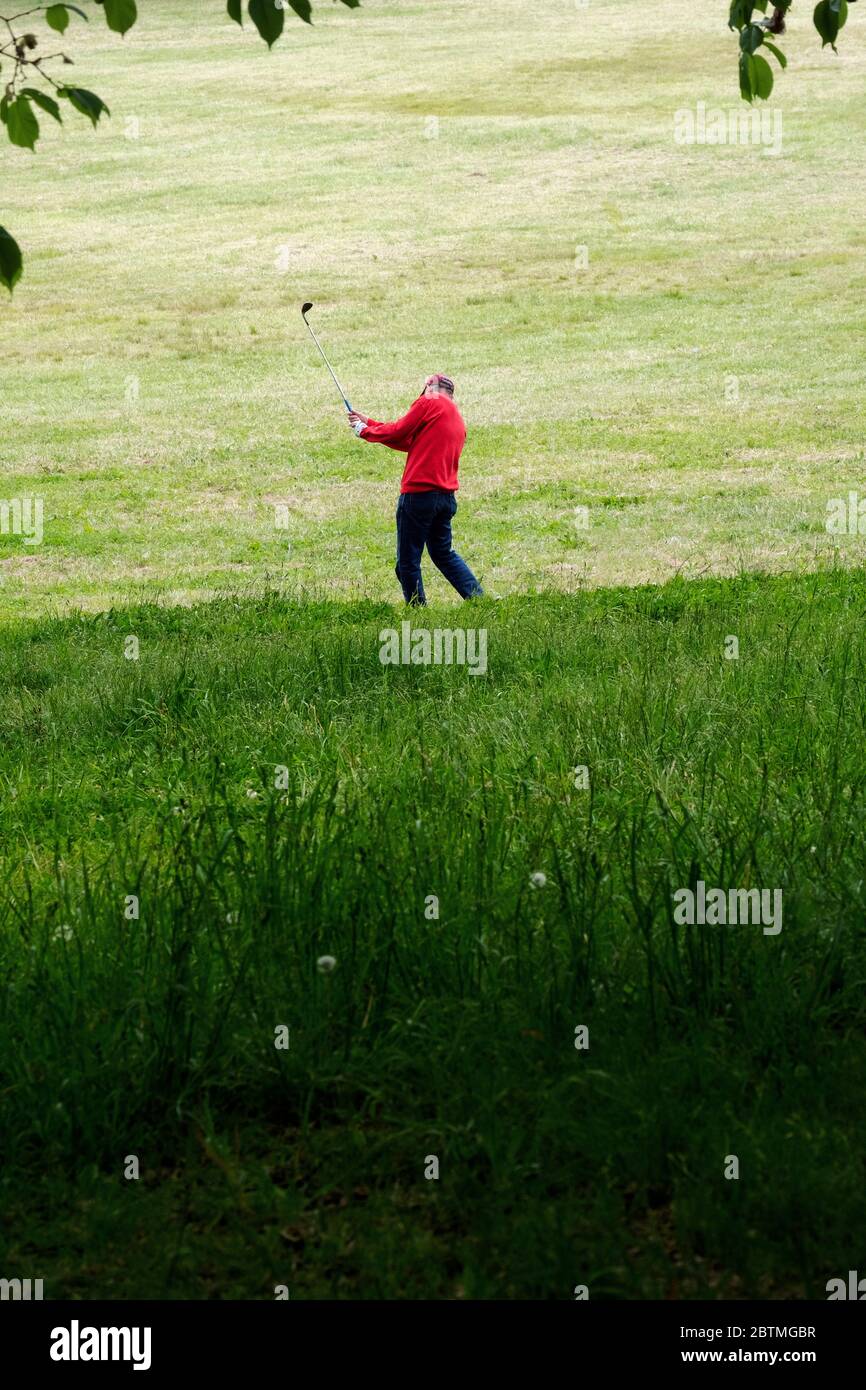Un uomo asiatico-americano pratica la sua oscillazione di golf in Little Bay Park a Whitestone, Queens, New York City. Foto Stock