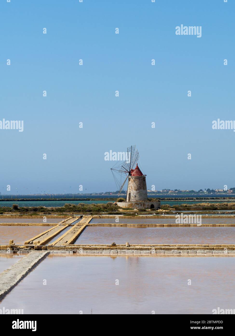 un antico mulino a vento e saline in sicilia Foto Stock