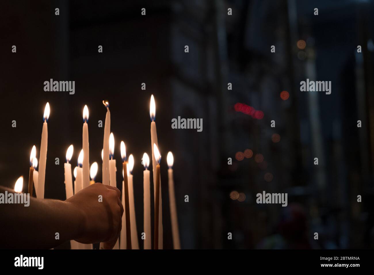 Adoratori che illuminano le candele sulla pietra di Annointing al Cruch del Santo Sepolcro a Gerusalemme, Israele Foto Stock