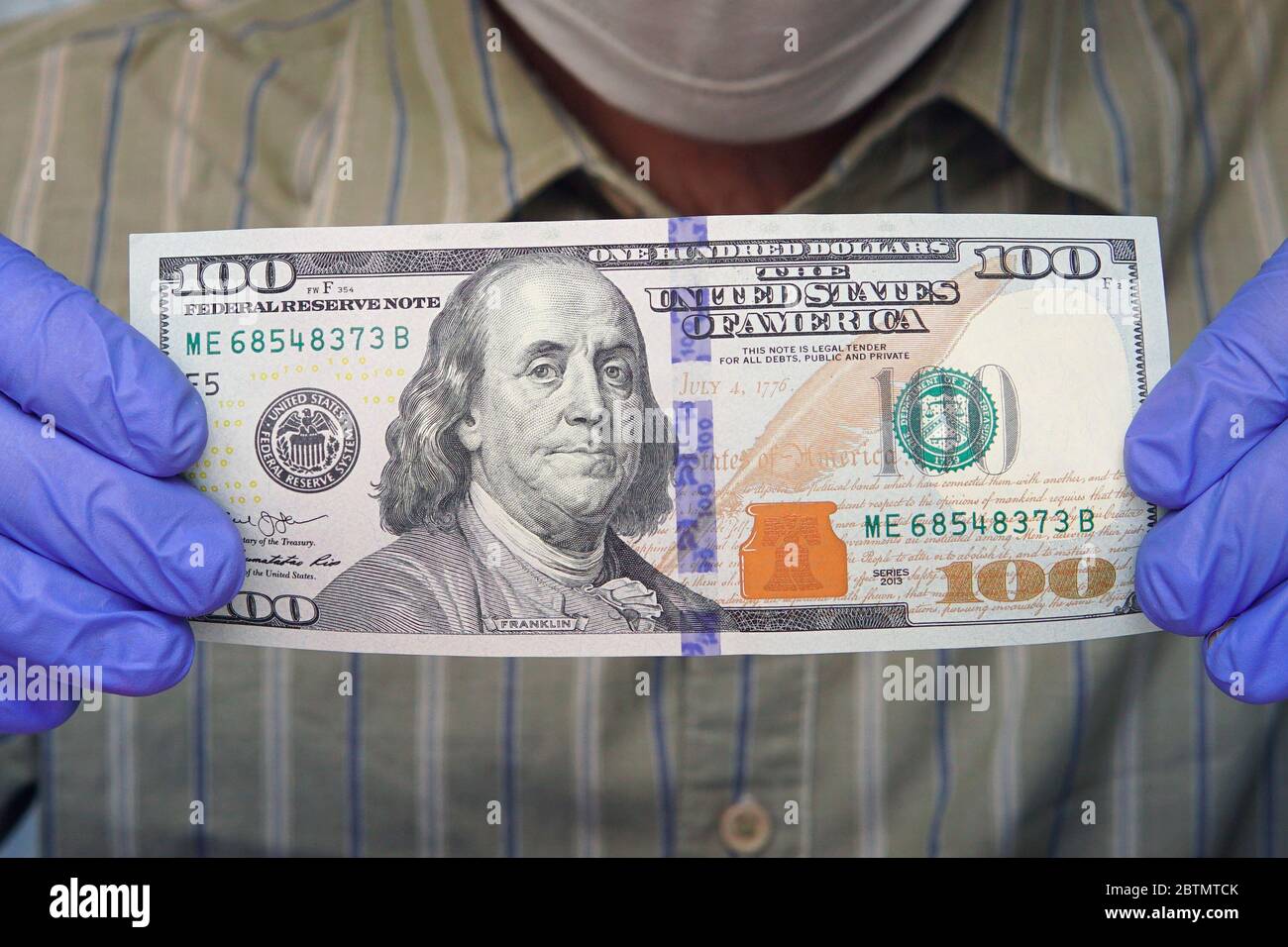 Virus money. L'uomo in guanti protettivi conta dollari di bollette. Salute e protezione delle mani da virus, germi e batteri durante l'epidemia di covidio influenzale Foto Stock