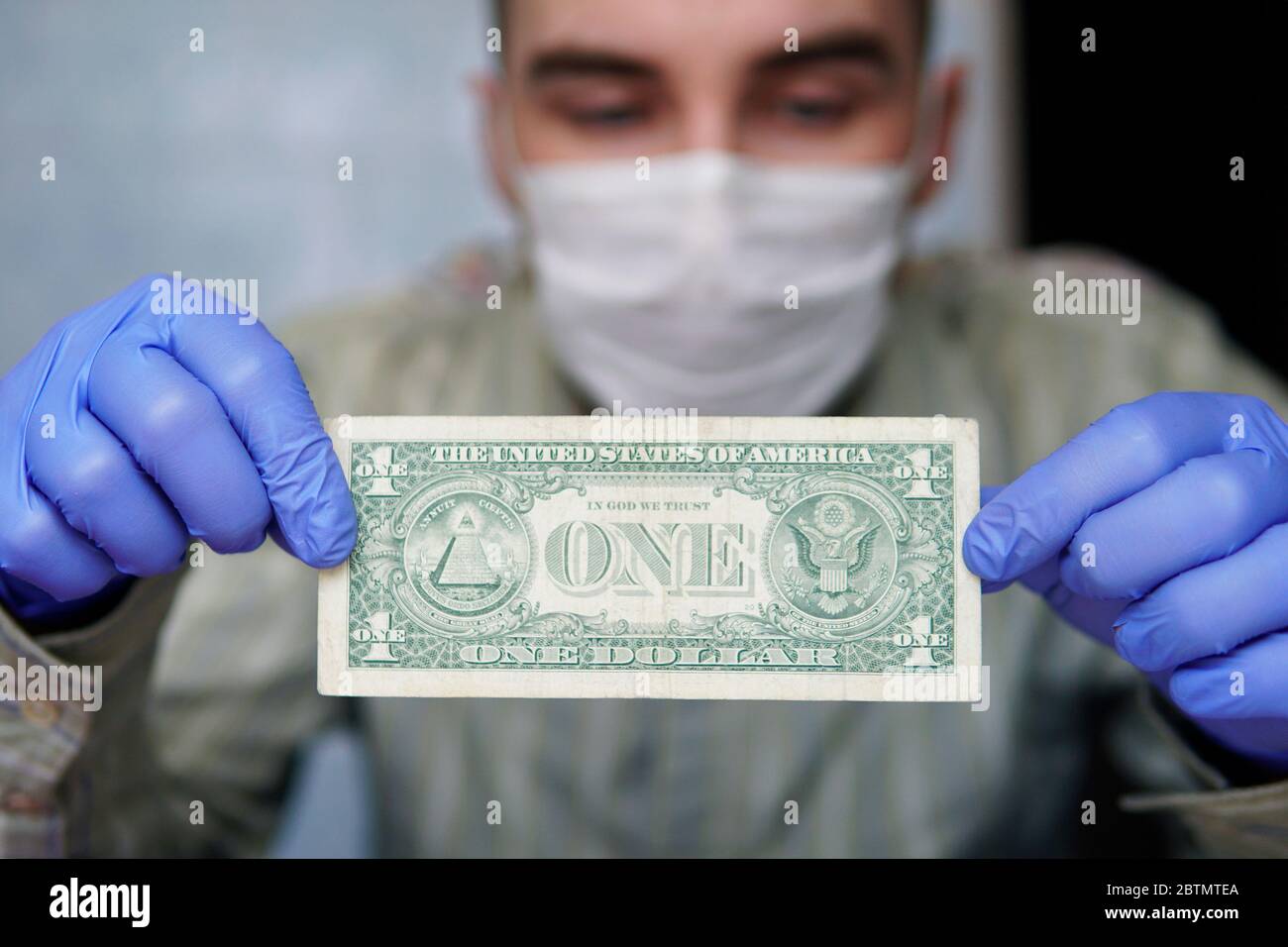 Virus money. L'uomo in guanti protettivi conta dollari di bollette. Salute e protezione delle mani da virus, germi e batteri durante l'epidemia di covidio influenzale Foto Stock
