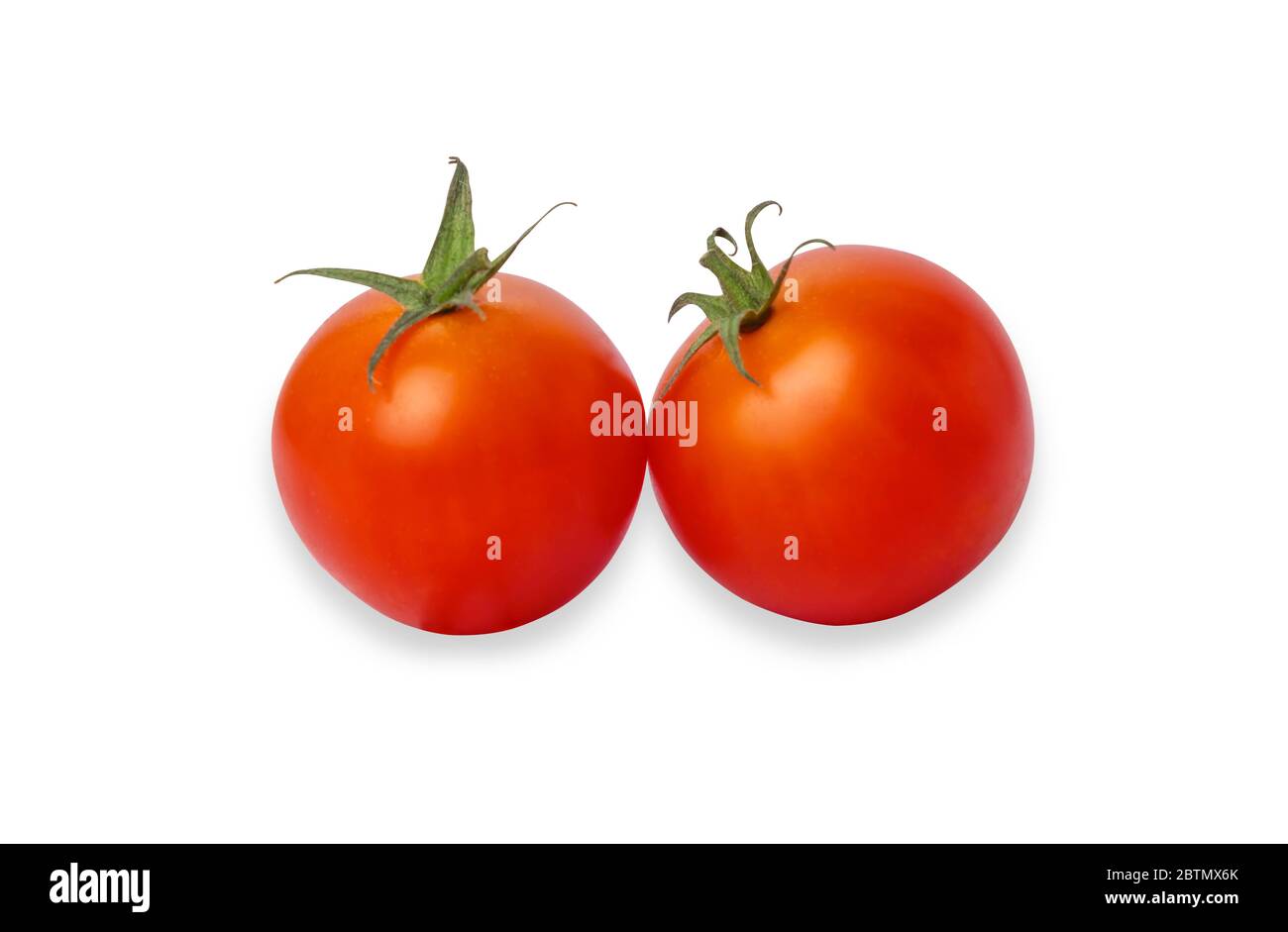 Due pomodori rossi isolato su uno sfondo bianco. Pomodoro ciliegino è un piccolo che ha un dolce, di tessuto sostanzioso e dispone di un piacevole aroma. E contiene il beta Foto Stock