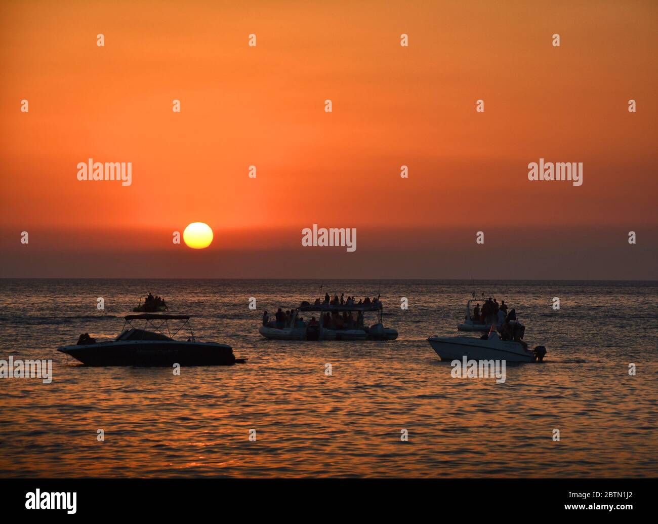 Persone che guardano il tramonto dalle barche in mare. Isola di Ibiza Foto Stock