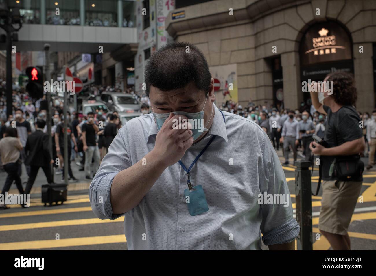 Hong Kong, Cina. 27 maggio 2020. Un uomo copre il suo naso intossicato da proiettili al pepe nel distretto centrale durante la dimostrazione contro la legge nazionale di sicurezza.la polizia di Hong Kong ha dispiegato un blocco di sicurezza con circa 3,000 ufficiali attraverso l'area centrale di Hong Kong. Le misure mirano a prevenire le proteste nei dintorni del Consiglio legislativo di Admiralty in quanto membri del parlamento discutono la legge per criminalizzare l'insulto all'inno nazionale. Credit: SOPA Images Limited/Alamy Live News Foto Stock