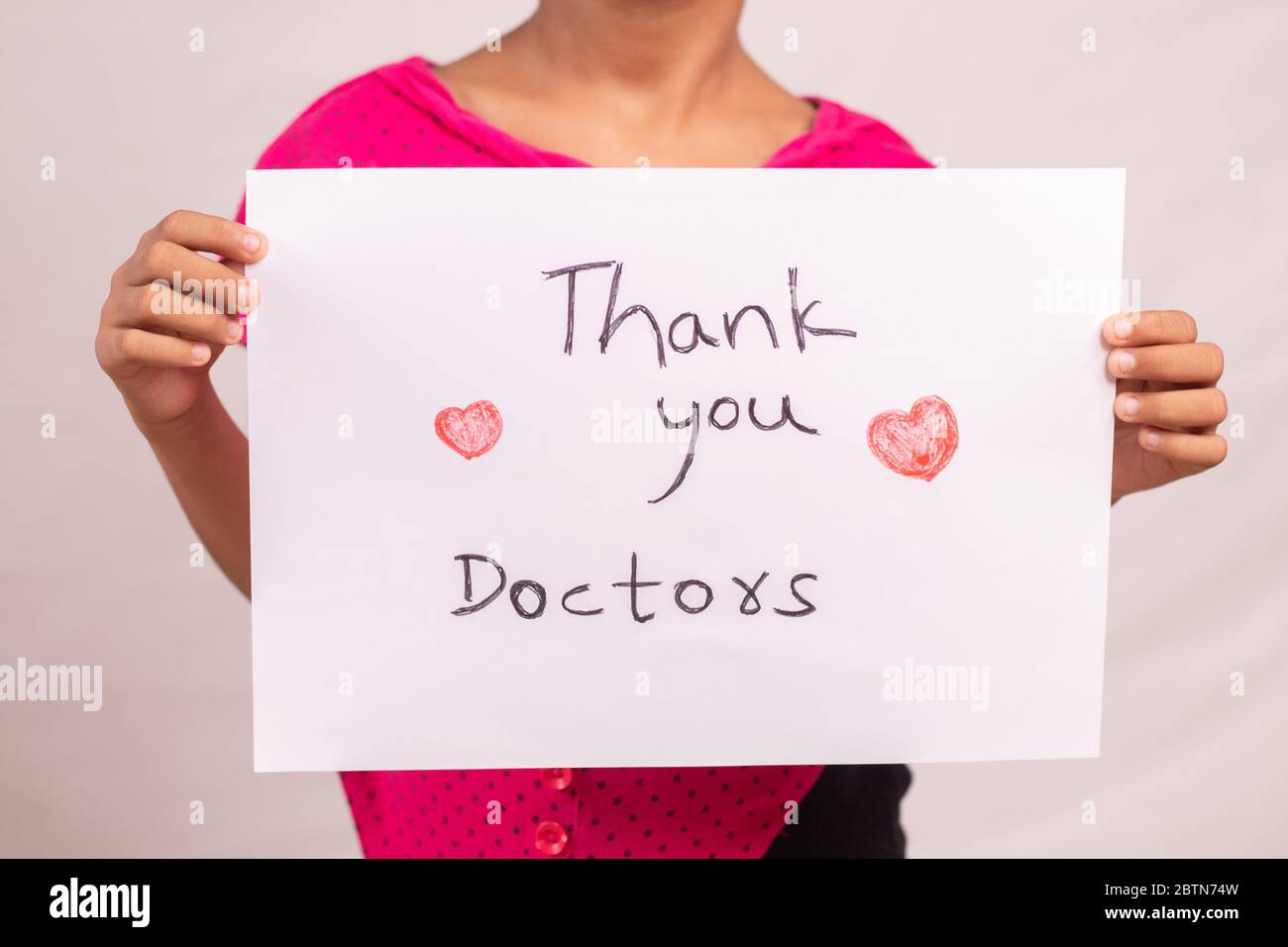 Kid Holding saluti ringrazianti per i medici e i medici di prima linea segnaletica, che lavorano durante il coronavirus o covid-19 pandemia Foto Stock